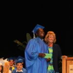 Grads receive awards – Scholarships further seniors’ education goals - A man holding a sign - Graduation ceremony