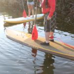 Locals invited to participate in SUP races this weekend - A group of people on a boat in the water - Sea kayak