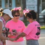 Hundreds join cancer walk - A woman talking on a cell phone - Car
