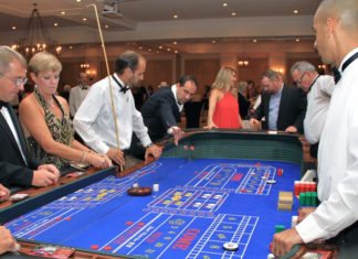 Gala raises funds for food bank - A man standing in front of a crowd - Indoor games and sports