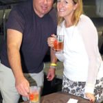Beer and bubbly flows at fest - A man and a woman sitting at a table eating food - Liquor