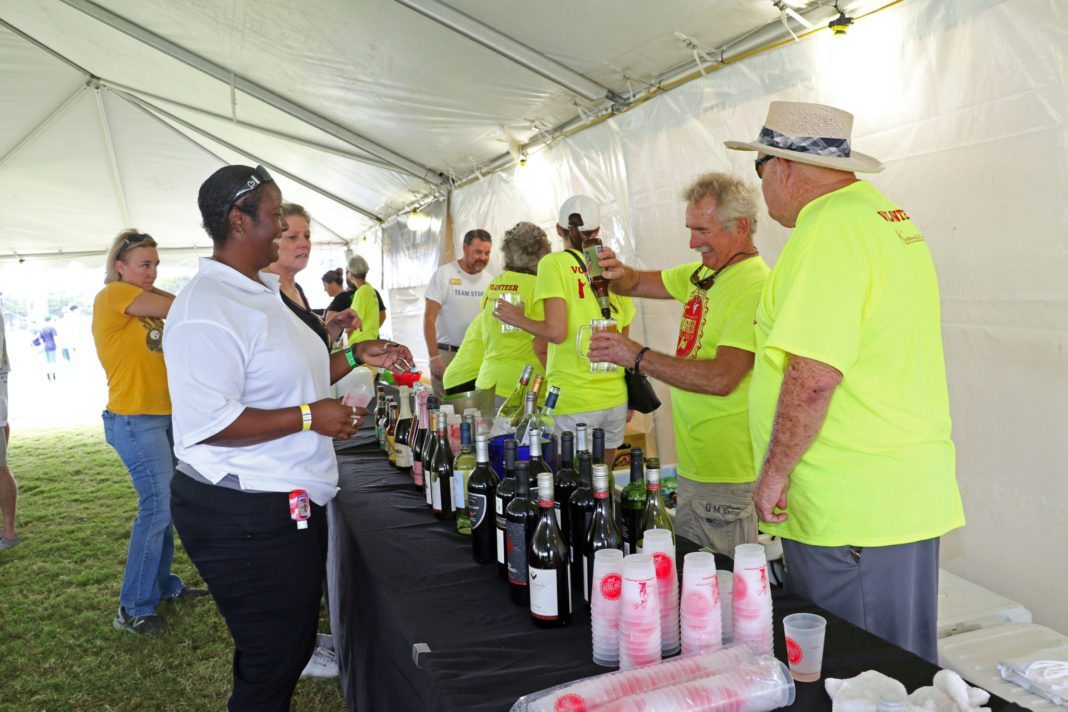 Beer and bubbly flows at fest - A group of people standing in a room - Race
