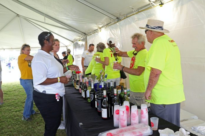 Beer and bubbly flows at fest - A group of people standing in a room - Race
