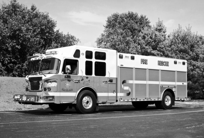City looks ahead to another fire station - A white bus parked in front of a truck - Car