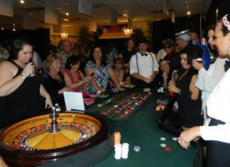 Gambling for Good - A group of people standing around a table - Poker
