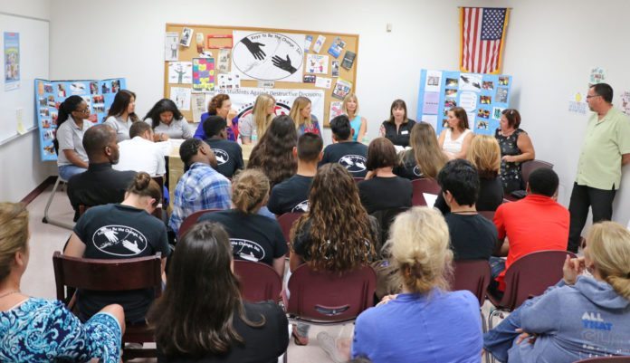 Teens host town hall meeting - A group of people in a room - Public Relations