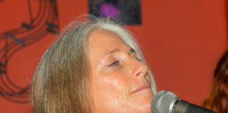 LOCAL SONGWRITER: Adrienne Z. - A close up of a person talking on a cell phone - Dan Fogelberg