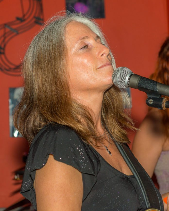 LOCAL SONGWRITER: Adrienne Z. - A close up of a person talking on a cell phone - Dan Fogelberg