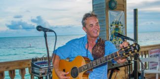 20 Questions with C.W. Colt - A man standing in front of a body of water - Guitar