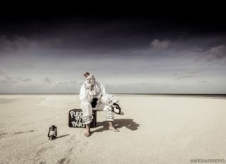 Puddles the clown returns to Key West Theater A couple of people that are standing in the sand on a beach - Florida Keys