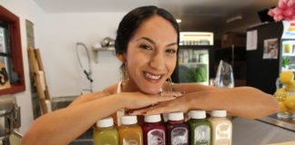 Good Girl Juice & Café opens in Village Square - A person holding a bottle of beer on a table - Good Girl's Juice Bar