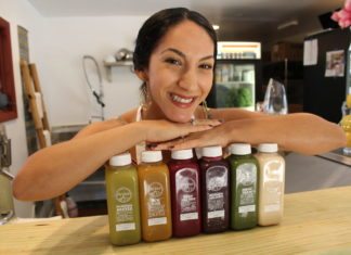 Good Girl Juice & Café opens in Village Square - A person holding a bottle of beer on a table - Good Girl's Juice Bar