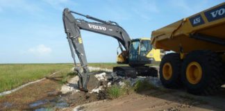 SFWMD destroys dam for flow - A truck driving down a dirt road - Road