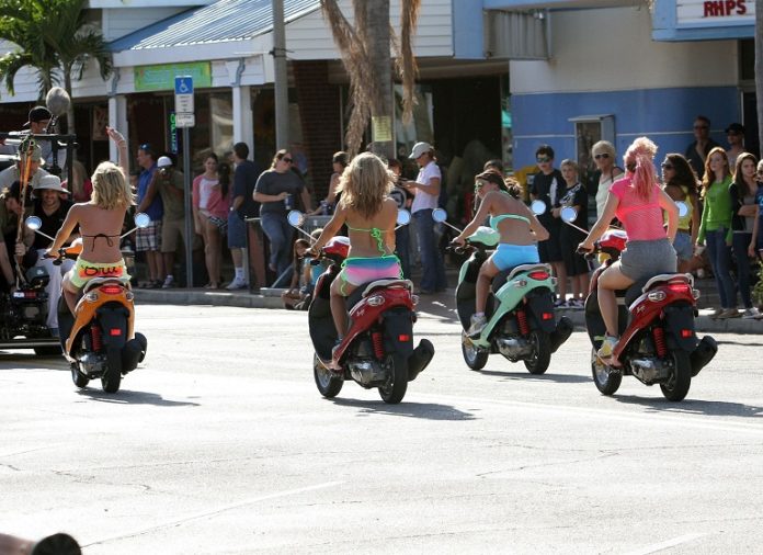 ON TWO WHEELS: Death and injury in Key West - A group of people riding on the back of a motorcycle - Scooter