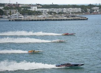Fast Futures: Sponsoring Kids at Powerboat Races - A small boat in a body of water with a city in the background - Motor Boat