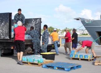Keys Donations head to the Bahamas - A group of people sitting at a table - Vehicle