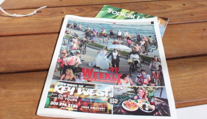 Key West Weekly: Now Delivering! - A stack of flyers on a table - Poster