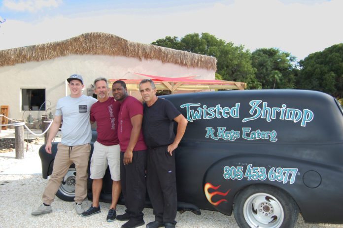 Twisted Shrimp - A group of people standing in front of a car posing for the camera - Twisted Shrimp