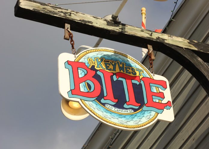 Key West Bite Restaurant: A Neighborhood Joint - A sign on a wooden pole - 