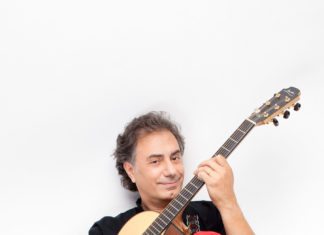 Guitarist returns for intimate concert - Pierre Bensusan holding a guitar - Pierre Bensusan
