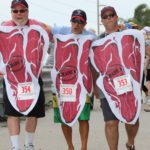Cow Key Bridge Run: Show us your teats - A group of people standing in front of a crowd - Cow Key