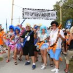 Cow Key Bridge Run: Show us your teats - A group of people standing in front of a crowd posing for the camera - Cow Key