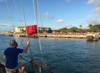 Down and Dirty at the Bloody Battle - A man holding a kite in a boat on a body of water - Sail