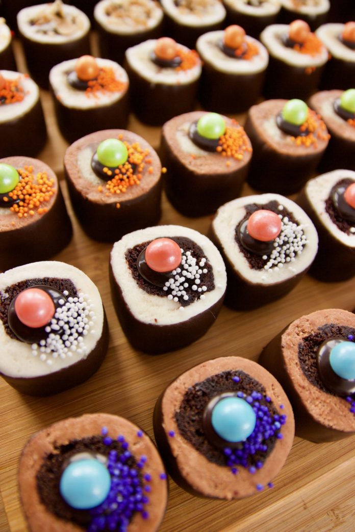 Meet the one-and-only Cupcake Sushi - A group of assorted doughnuts on a table - Chocolate