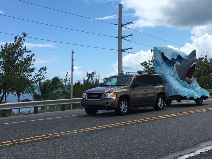 SHARK! Massive sculpture makes move to Marathon - A truck is parked on the side of a road - Luxury vehicle