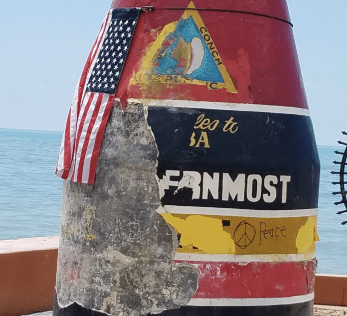 WHAT’S NEXT? Thoughts on Irma, 10 days after - A sign on the side of the water with Southernmost point buoy in the background - Southernmost Point of the Continental US
