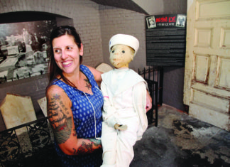 Robert the Doll Returns to Upper Keys - A person holding a teddy bear posing for the camera - Robert