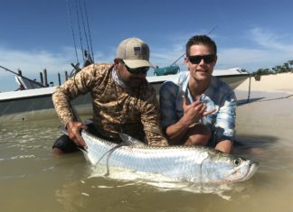 Honor, Courage, Commitment - A man holding a fish on a boat in the water - Recreational fishing