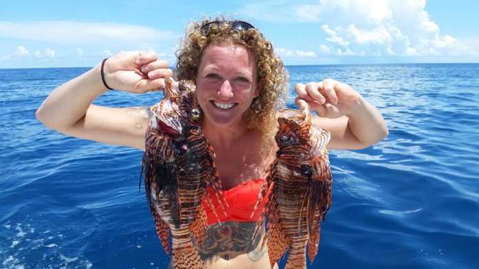 Multi-tasking with Rachel Bowman - A person standing next to a body of water - Red lionfish