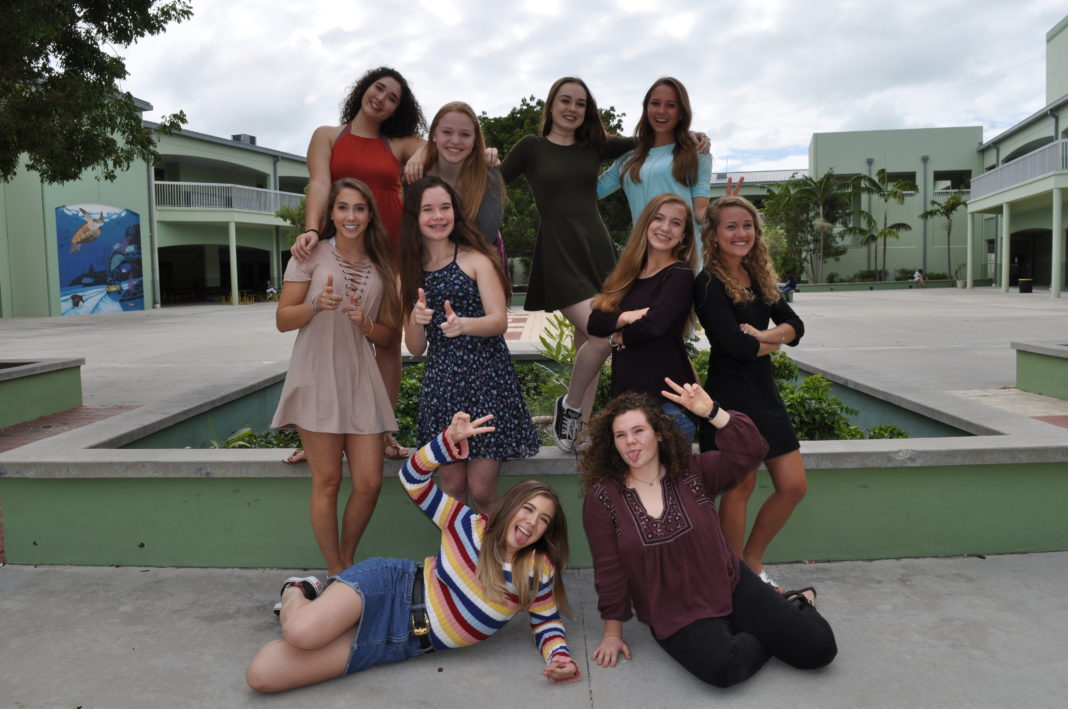 Meet the Miss Coral Shores finalists - A group of people sitting on a bench posing for the camera - Coral Shores High School