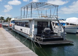PROPOSAL OPPOSED Roots Reach Keys - A boat is docked next to a body of water - Houseboat