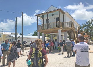 Ribbon cut on first ‘Maggie House’ - A group of people standing outside of a building - Florida Keys