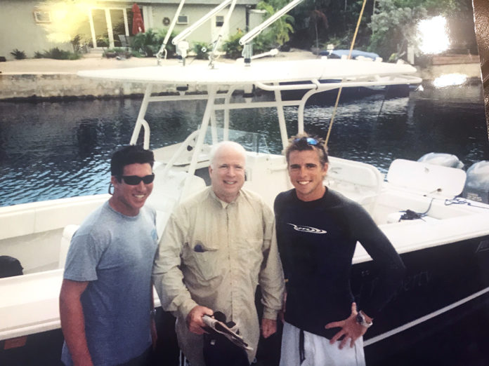 John McCain et al. standing on a boat posing for the camera - Niall Horan