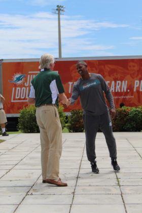 Dolphins to Dolphins – NFL foundation makes huge donation to MHS - A man standing on a sidewalk - Car