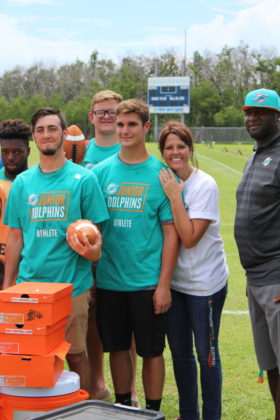 Dolphins to Dolphins – NFL foundation makes huge donation to MHS - Troy Drayton et al. posing for the camera - Car