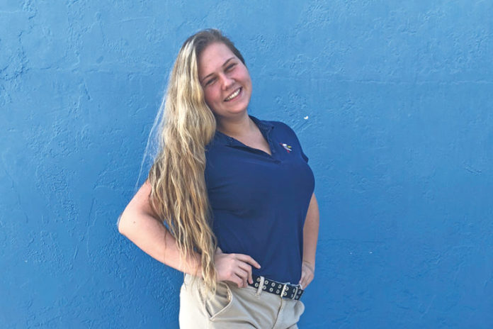 A woman standing in front of a body of water posing for the camera - Blond