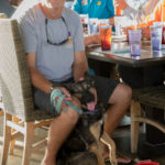 25 Disabled Veterans Are Honored - A group of people sitting at a table with a dog - Dog