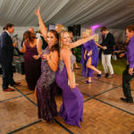 Purple Pumpkin Gala - A group of people standing in front of a crowd - Wedding reception