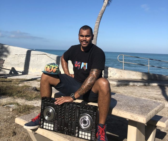 DJ FIJI brings multicultural experiences from global waters - A man sitting on a bench next to a body of water - Florida