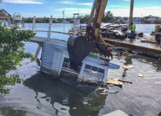 Remains of Irma: Canal Cleanup Nears Completion - A boat is docked next to a body of water - Florida Keys