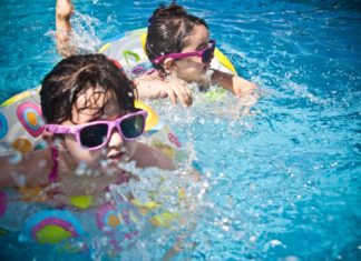 Our Barefoot Doctor Offers Sunscreen Tips for the Kids - A child swimming in a pool of water - Summer camp