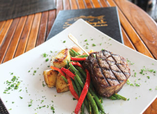 Weekly EATS:  Snooks Bayside Keeps the Vibe Alive - A plate of food with a fork and knife - Beef tenderloin