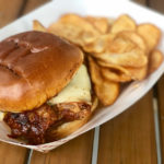 Food truck finds: Check out the Blind Pig - A sandwich sitting on top of a wooden table - Pulled pork