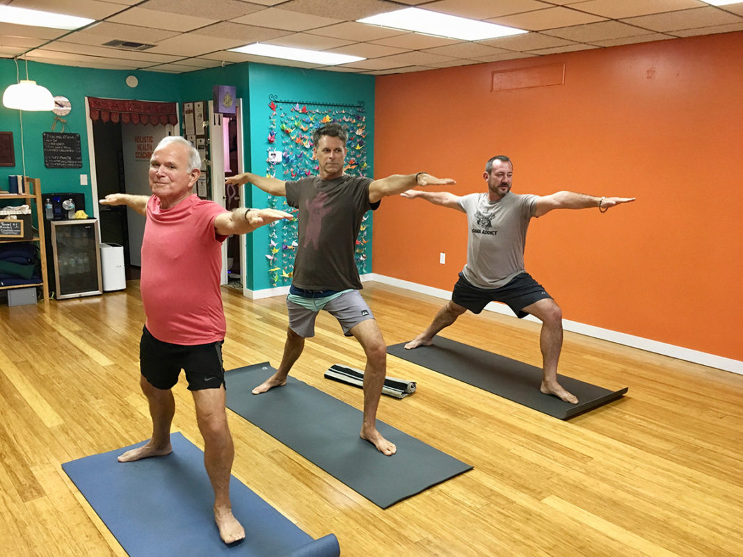 Males in Yoga increase in the Upper Keys - A group of people standing in a room - Yoga