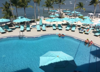 A peek inside Key Largo’s Luxurious Bungalows - A group of people sitting at a beach umbrella in the water - Florida Keys