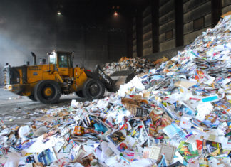 Recycling rates are increasing, but so is ‘contamination’ - A construction vehicle next to a truck - Recycling